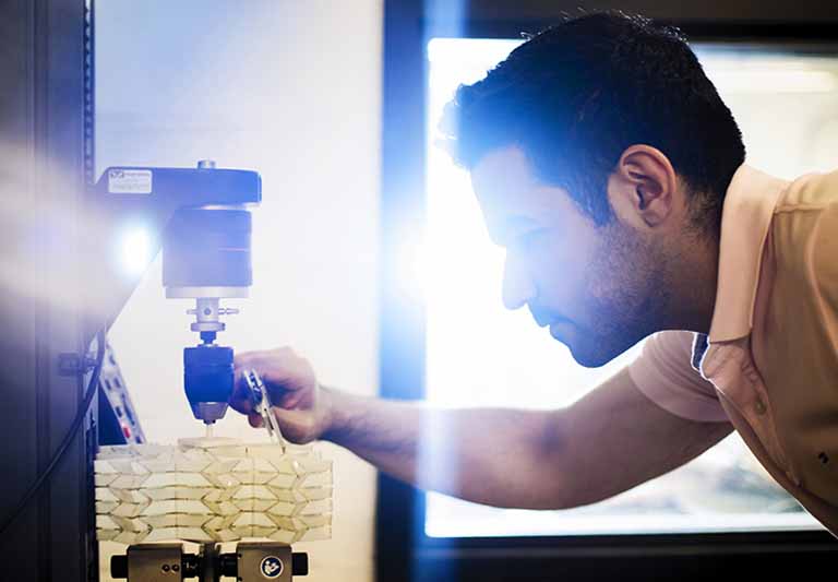 man works with 3D printer with origami shapes